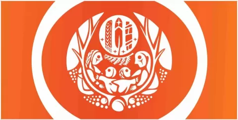 A white design on an orange flag. It depicts a family with two children and a series of Indigenous symbols and medicines from First Nations, Metis and Inuit culture.